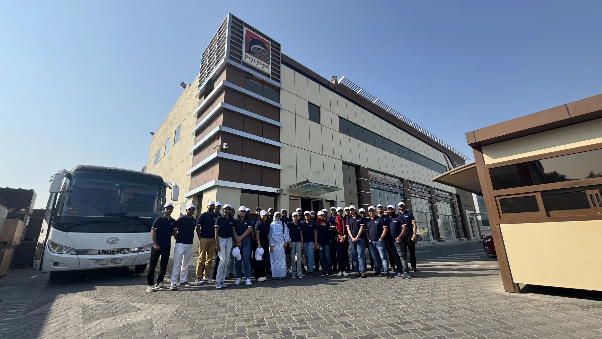 Dolphin Group team gathered beside a bus before the desert clean-up